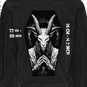 Puede incluir: Chaqueta vaquera negra con un gráfico blanco de una cabra con cuernos en un ataúd. El gráfico mide 36 cm de alto y 22 cm de ancho.