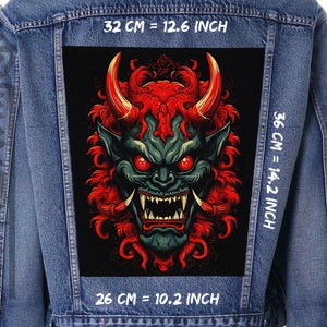 Peut inclure: Une veste en jean avec un patch noir représentant une illustration de démon japonais rouge et vert. Le patch mesure 32 cm de large, 36 cm de haut et 26 cm de profondeur.