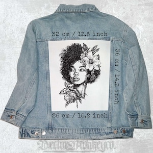Op de afbeelding: Zwart-witte lijntekening van een vrouw met een afrokapsel en bloemen in haar haar. De afbeelding is gedrukt op een witte achtergrond en meet 32 cm breed en 36 cm hoog.