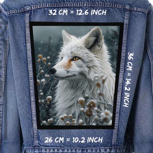 Puede incluir: Una chaqueta vaquera con un parche que presenta un zorro ártico blanco en un entorno de bosque nevado. El parche tiene medidas en centímetros y pulgadas: 32 cm = 12,6 pulgadas, 36 cm = 14,2 pulgadas, 26 cm = 10,2 pulgadas.