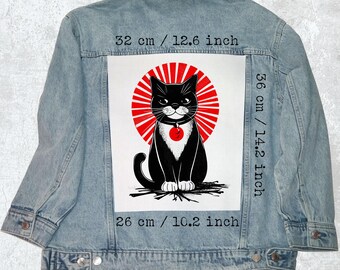Peut inclure: Veste en jean bleu clair avec un grand motif au dos. Le motif représente un chat noir avec un motif de soleil rouge. Le motif mesure 32 cm de large, 36 cm de haut et 26 cm en bas.