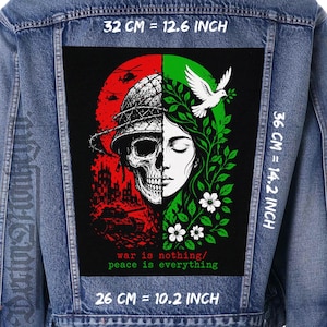 May include: A blue denim jacket featuring a large rectangular patch on the back. The patch displays a split design: a red side with a skull in a helmet, tanks, and helicopters, and a green side with a dove and flowers. Text reads: war is nothing/ peace is everything. Dimensions are 32 cm by 36 cm, or 12.6 inches by 14.2 inches.