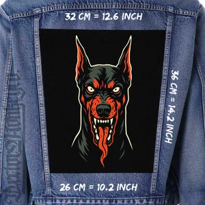 May include: A denim jacket with a large, rectangular patch featuring a menacing Doberman Pinscher illustration. The dog is depicted in black, red, and white, with its tongue hanging out. The patch measures 12.6 inches by 14.2 inches and 10.2 inches.