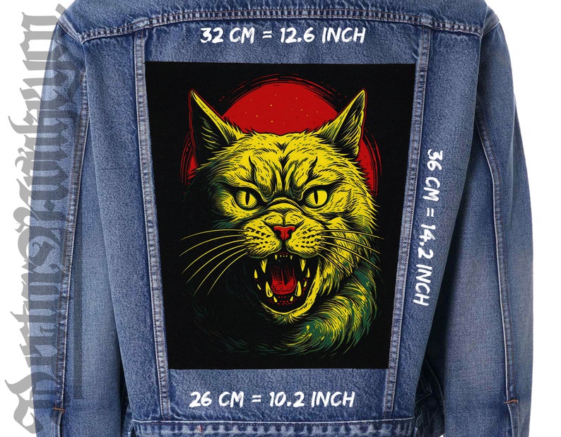 May include: A denim jacket with a black patch featuring a yellow and green cat with red eyes and a red background. The patch is 36 cm tall and 26 cm wide. The jacket has white text that says "32 CM = 12.6 INCH", "36 CM = 14.2 INCH", and "26 CM = 10.2 INCH".