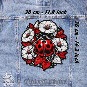Könnte beinhalten: Ein Aufbügler mit einem roten Marienkäfer-Design, schwarzen Punkten und weißen Blumen mit roten Blättern. Der Aufnäher ist 30 cm x 36 cm groß. Der Text "IRON ON PATCH" ist sichtbar.