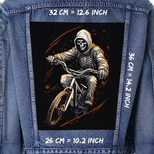 May include: A black and white illustration of a skeleton riding a bicycle. The skeleton is wearing a hooded sweatshirt and has a skull for a head. The bicycle has a black frame and orange wheels. The image is on a black background with orange accents. The image is 32 cm wide, 36 cm tall, and 26 cm deep.