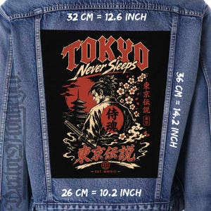 May include: A blue denim jacket featuring a large rectangular back patch with a graphic of a samurai, a pagoda, and cherry blossoms. The text reads Tokyo Never Sleeps, Tokyo Densetsu, and Est. MMXIII. The patch measures 32 cm by 36 cm.