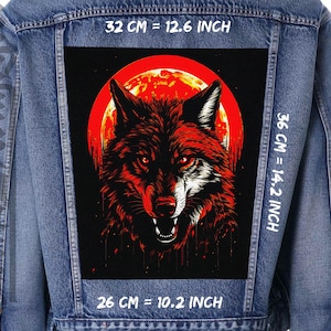 Könnte beinhalten: Eine Jeansjacke mit einem schwarzen und roten Wolf-Patch auf der Rückseite. Der Patch zeigt einen Wolf, der zu einem roten Mond heult. Der Text "32 CM = 12.6 INCH", "36 CM = 14.2 INCH" und "26 CM = 10.2 INCH" ist auf der Jacke aufgedruckt.