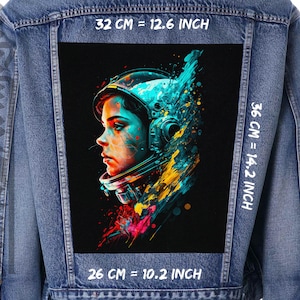 Könnte beinhalten: Eine Jeansjacke mit einem bunten Astronauten-Illustrationspatch auf der Rückseite. Der Patch ist 32 cm breit und 36 cm hoch. Der Text "32 CM = 12.6 INCH", "36 CM = 14.2 INCH" und "26 CM = 10.2 INCH" ist auf der Jacke aufgedruckt.
