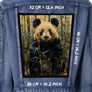 Op de afbeelding: Een spijkerjack met een zwarte patch waarop een pandabeer in een bamboebos te zien is. De patch heeft de tekst "32 CM = 12.6 INCH", "36 CM = 14.2 INCH" en "26 CM = 10.2 INCH" erop gedrukt.