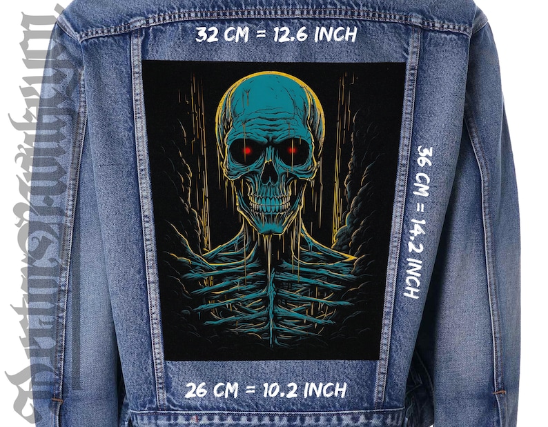 May include: A blue denim jacket with a black patch featuring a blue and green skull with red eyes. The patch is 32 cm wide, 36 cm tall, and 26 cm deep. The text "32 CM = 12.6 INCH", "36 CM = 14.2 INCH", and "26 CM = 10.2 INCH" is printed on the jacket.