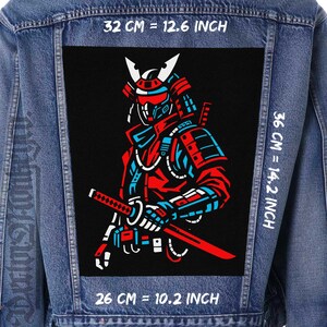May include: A denim jacket with a large black patch featuring a red, blue, and white samurai warrior design. The patch measures 32 cm wide by 36 cm high, with a sword. The text on the patch reads "32 CM = 12.6 INCH", "36 CM = 14.2 INCH", and "26 CM = 10.2 INCH".