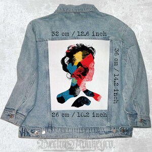 May include: A denim jacket with a colorful abstract portrait patch sewn on the back. The patch measures 14.2 inches by 10.2 inches.
