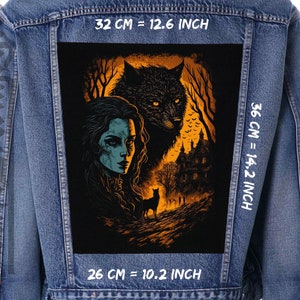 May include: A denim jacket with a black and orange embroidered patch featuring a woman with long dark hair and a wolf. The patch has the text "32 CM = 12.6 INCH", "36 CM = 14.2 INCH", and "26 CM = 10.2 INCH".