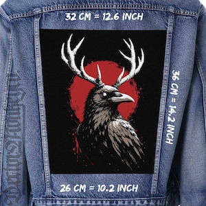 Puede incluir: Una chaqueta de mezclilla azul con un parche rectangular grande en la espalda. El parche muestra un cuervo negro con astas blancas sobre un fondo circular rojo. Las dimensiones son 32 cm de ancho por 36 cm de alto, con una base de 26 cm.