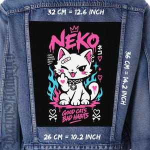 Könnte beinhalten: Eine blaue Jeansjacke mit einem großen rechteckigen schwarzen Aufnäher auf der Rückseite. Der Aufnäher zeigt eine weiße Katze mit Pflaster, Kettenhalsband und Mittelfinger-Geste, umgeben von blauen Flammen, rosa Herzen und dem Text NEKO, CUTE CHAOS BETTER DAYS und GOOD CATS BAD HABITS. Die Maße betragen 32 cm mal 36 cm mal 26 cm.