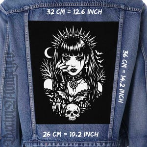 Könnte beinhalten: Ein schwarz-weißer Gothic-Aufnäher mit einer Frau mit Krone, Fledermäusen und einem Totenkopf, auf einer Jeansjacke. Der Aufnäher ist 32 cm breit, 36 cm hoch und 26 cm lang. Der Text "32 CM = 12.6 INCH", "36 CM = 14.2 INCH" und "26 CM = 10.2 INCH" ist enthalten.