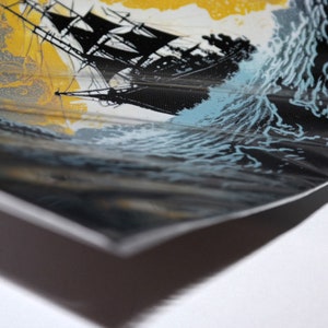 Op de afbeelding: Een prent die een zwart zeilschip op een stormachtige zee afbeeldt. Het kunstwerk toont een gele lucht, donkere golven en een zwart schip met gedetailleerde tuigage. De prent staat op een getextureerd oppervlak, met een witte rand.