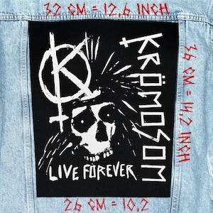 May include: A black patch with a white skull graphic and the text "Kromosom Live Forever" is sewn onto a light blue denim jacket. The patch measures 12.6 inches wide and 14.2 inches tall.