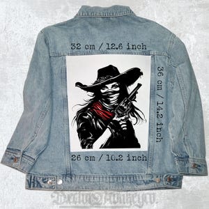Op de afbeelding: Zwart-witte illustratie van een vrouw met een cowboyhoed en een bandana, die een pistool vasthoudt. De afbeelding is gedrukt op een witte patch, die 36 cm bij 26 cm meet.