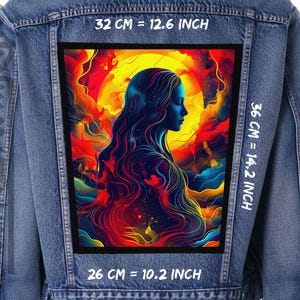 Pode incluir: Uma jaqueta de ganga com um remendo de arte abstrata colorido costurado nas costas. O remendo apresenta uma mulher com cabelo comprido e solto e um fundo vibrante. O texto "32 CM = 12.6 INCH", "36 CM = 14.2 INCH" e "26 CM = 10.2 INCH" está impresso na jaqueta.