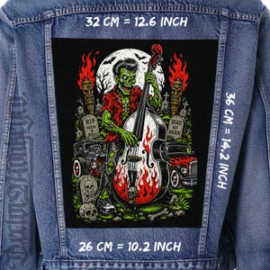 May include: A blue denim jacket featuring a large rectangular back patch with a green zombie playing a double bass. The graphic includes flames, tombstones with text, and hot rod cars. The patch measures 10.2 inches by 14.2 inches, with a 12.6 inch width.