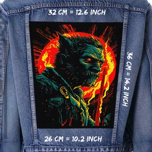 Peut inclure: Veste en jean avec un grand écusson rectangulaire au dos. L'écusson présente une illustration de monstre vert et rouge sur un fond rouge et jaune. L'écusson mesure 32 cm de large et 36 cm de haut.