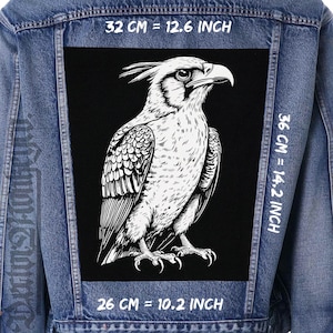 May include: A denim jacket with a large black patch featuring a detailed white illustration of a bird of prey. The patch measures 12.6 inches wide, 14.2 inches tall, and 10.2 inches across. The jacket is blue.