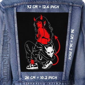 Op de afbeelding: Spijkerjasje met een groot zwart patch met een rode duivelvrouw illustratie. De patch meet 32 cm bij 36 cm, met de tekst "32 CM = 12.6 INCH" en "36 CM = 14.2 INCH".