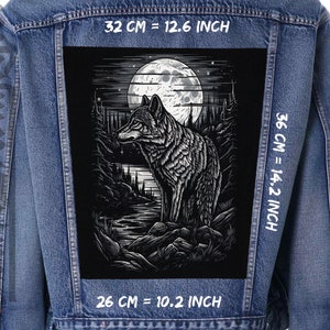 May include: A denim jacket with a large black and white patch featuring a wolf in a forest scene under a full moon. The patch measures 32 cm wide and 36 cm tall.