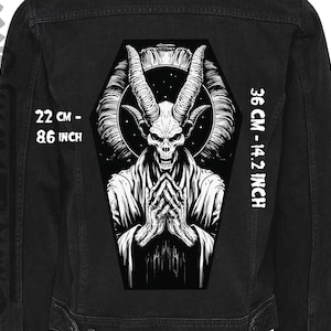 May include: Black and white illustration of a demon with horns and a halo, in a coffin shape. The image is on a black denim jacket. The text "22 CM - 8.6 INCH" and "36 CM - 14.2 INCH" is printed on the jacket.
