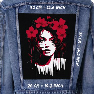 Könnte beinhalten: Ein schwarzes und rotes Grafikdesign einer Frau mit roten Blumen im Haar. Das Design befindet sich auf einer Jeansjacke mit weißem Text, der "32 CM = 12.6 INCH", "36 CM = 14.2 INCH" und "26 CM = 10.2 INCH" lautet.