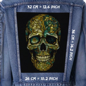 May include: A denim jacket with a large embroidered skull patch on the back. The skull is gold and green with intricate details. The patch measures 12.6 inches wide by 14.2 inches tall.