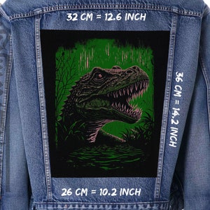 May include: A denim jacket with a green and black patch featuring a dinosaur with sharp teeth. The patch is 12.6 inches wide, 14.2 inches tall, and 10.2 inches deep.