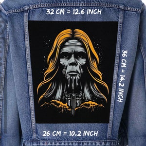 Peut inclure: Une illustration en noir et blanc d'une créature aux cheveux longs et à la barbe, sur une veste en jean. L'illustration mesure 26 cm de large, 32 cm de haut et 36 cm de long.