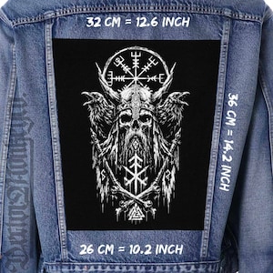 May include: A blue denim jacket featuring a large black rectangular patch with a white graphic of a horned skull, two ravens, a Vegvisir compass, and a Valknut symbol. The patch measures 32 cm by 36 cm, with a bottom width of 26 cm.