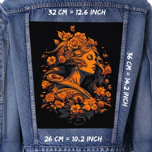Könnte beinhalten: Jeansjacke mit einem großen, schwarzen Aufnäher mit dem Profil einer Frau, umgeben von orangefarbenen Blumen. Der Aufnäher ist 32 cm breit und 36 cm hoch. Der Aufnäher der Jacke hat die Maße 26 cm breit und 36 cm hoch.