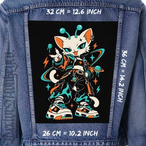 Puede incluir: Una chaqueta de mezclilla azul con un parche rectangular grande en la espalda que muestra un gato blanco antropomórfico. El parche mide 32 cm por 36 cm, con un ancho de 26 cm en la parte inferior. El gato viste chaqueta, pantalones cargo y zapatillas.
