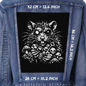 May include: A denim jacket with a large, black patch featuring a white illustration of a rat holding various objects, including a key and skulls. The patch measures 12.6 inches wide, 14.2 inches tall, and 10.2 inches across.