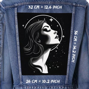 Op de afbeelding: Spijkerjasje met een groot zwart-wit embleem met het profiel van een vrouw, een sterrenachtergrond en een halo. De patch is 32 cm breed en 36 cm hoog.