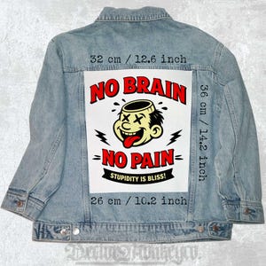 May include: Light blue denim jacket with a large graphic on the back. The graphic features a cartoon character with the words "NO BRAIN - NO PAIN" and "STUPIDITY IS BLISS!". The graphic measures 12.6 inches wide, 14.2 inches high, and 10.2 inches long.
