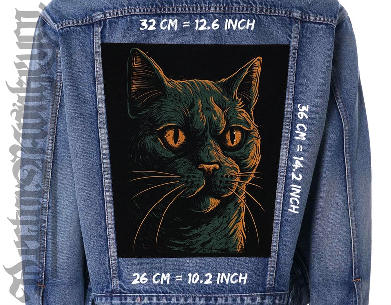 May include: A blue denim jacket with a large, rectangular patch depicting a stylized cat's face. The cat is green and orange, with orange eyes. The patch measures 26 cm wide by 36 cm tall.