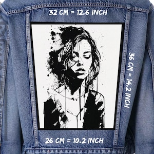 Pode incluir: Casaco de ganga com um grande patch retangular. O patch apresenta uma ilustração a preto e branco do rosto de uma mulher, medindo 32 cm por 36 cm (12,6 polegadas x 14,2 polegadas). O casaco tem um design clássico.