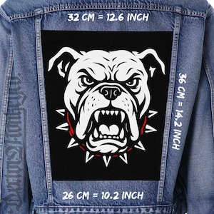 Könnte beinhalten: Jeansjacke mit einem großen, schwarzen Aufnäher mit einer weißen Bulldoggen-Grafik. Der Bulldogge hat einen wütenden Ausdruck mit gebleckten Zähnen und einem roten Stachelhalsband. Der Aufnäher misst 32 cm mal 36 cm und 26 cm.