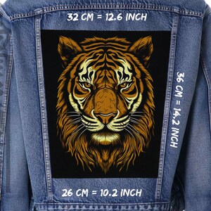 Könnte beinhalten: Eine schwarze und braune Tigergesichtsgrafik auf schwarzem Hintergrund. Die Grafik ist 32 cm breit, 36 cm hoch und 26 cm tief.