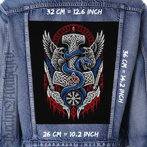 May include: A blue denim jacket featuring a large rectangular back patch with a black background. The patch displays a Norse-inspired graphic of a hammer, two ravens, a blue snake, and a compass symbol. Dimensions are 32 cm by 36 cm by 26 cm.