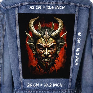 Könnte beinhalten: Eine Jeansjacke mit einem großen Patch auf dem Rücken. Der Patch zeigt eine rote und schwarze Illustration eines Dämons mit goldenen Hörnern und einem bedrohlichen Ausdruck. Der Text "32 CM = 12.6 INCH", "36 CM = 14.2 INCH" und "26 CM = 10.2 INCH" ist auf der Jacke aufgedruckt.