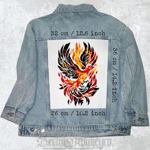 May include: A denim jacket with a large iron-on patch of a phoenix rising from flames. The patch is 14.2 inches tall and 10.2 inches wide. The patch is white with black, red, and orange colors.