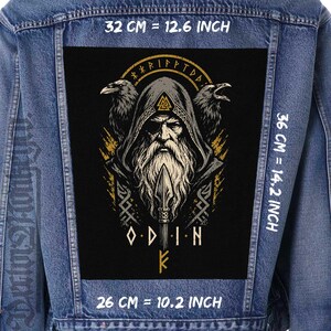 May include: A blue denim jacket featuring a large rectangular back patch with a graphic illustration of Odin wearing a hooded cloak and an eyepatch, flanked by two ravens. The patch includes the text ODIN and measures 12.6 inches by 14.2 inches.