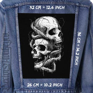 Könnte beinhalten: Schwarzweißes Grafik von zwei ineinander verschlungenen Schädeln mit Blitzen im Hintergrund. Die Grafik befindet sich auf einem schwarzen Patch mit weißem Text um die Ränder, der die Größe des Patches in Zentimetern und Zoll angibt.
